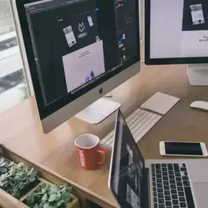 Dual workstation setup showing UI/UX design wireframes and digital marketing and SEO strategy analysis